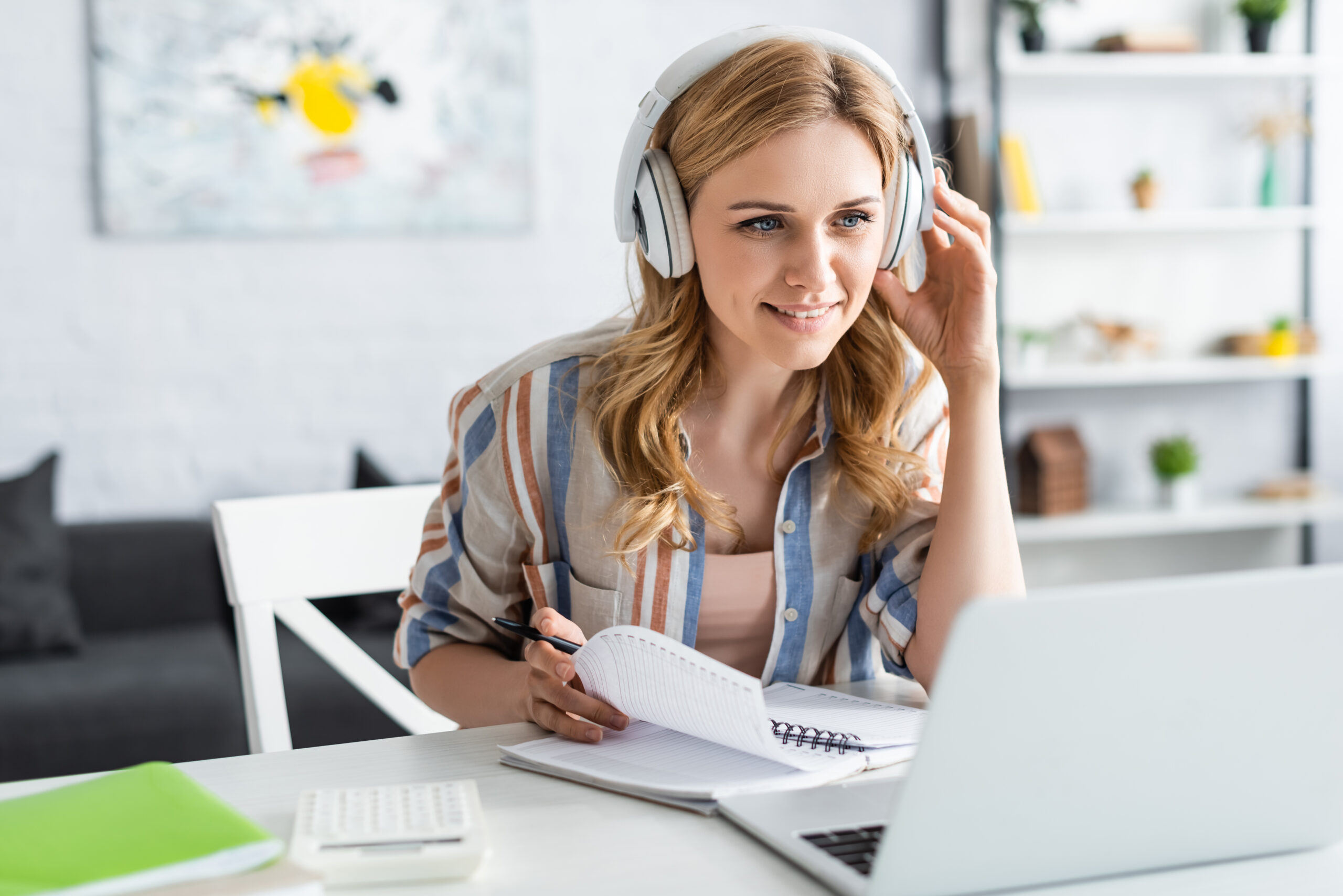 Woman with headphones in front of laptop during e-learning